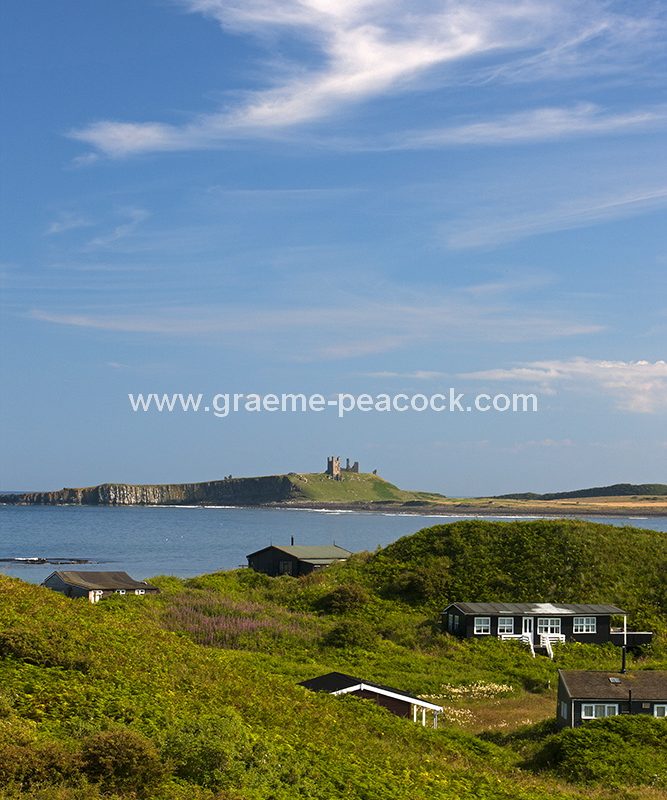 Beach bungalows on Embleton Links overlooking Dunstanburgh Castle near Embleton, Northumberland
